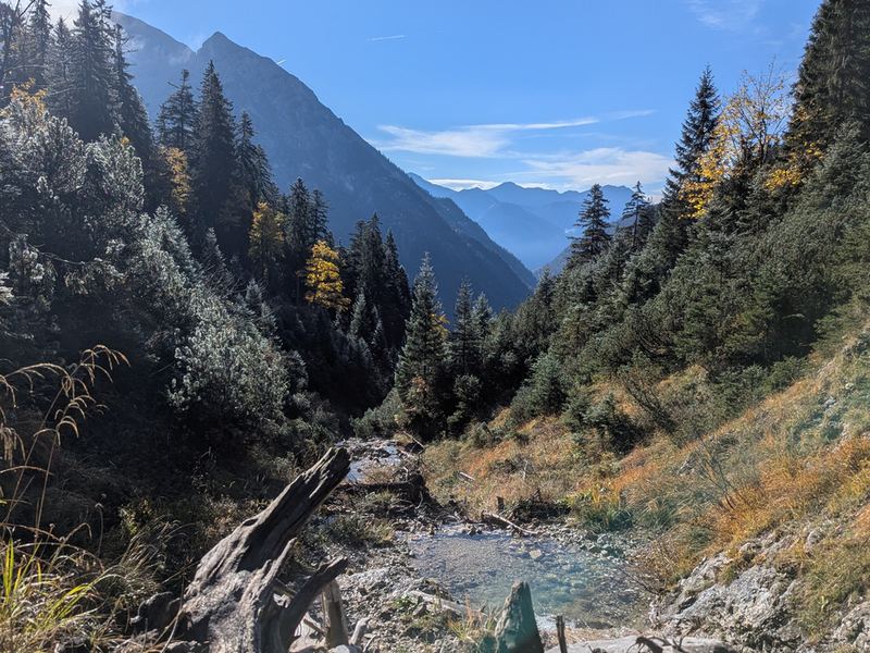 Blick talauswärts über Geröll auf bewaldete Hänge