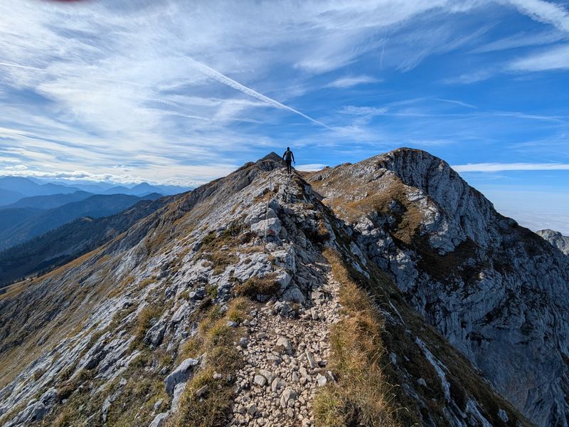 Der Gipfelgrat der Hochplatte, auf der Schneide eine Wanderin