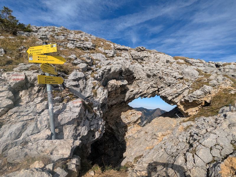 Das Fensterl, ein Felsentor am Grat, daneben der Wegweiser
