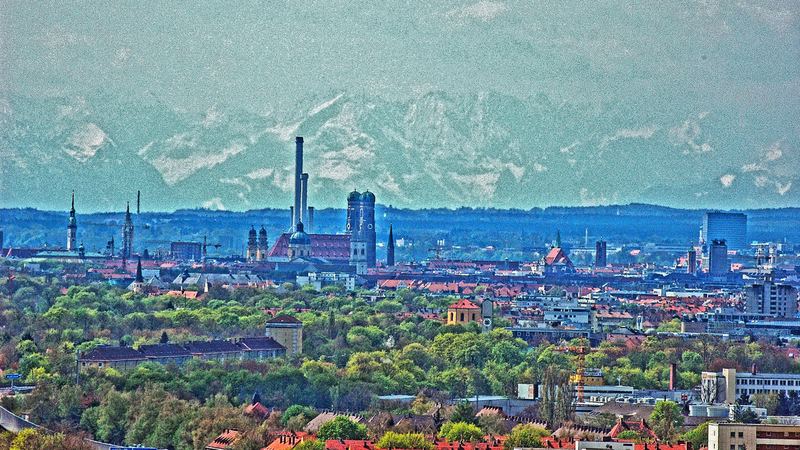 München auf der Schotterebene, die Alpenkette am Horizont.