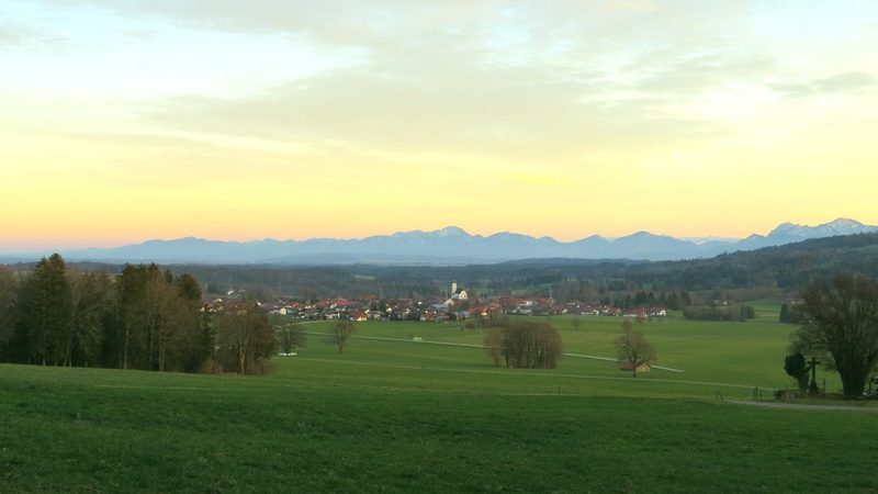 Hügellandschaft des Pfaffenwinkels bei Böbing mit den Bayerischen Voralpen am Horizont