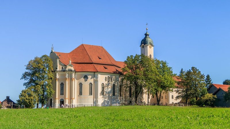 Die Wieskirche von Süd-Südwest, freistehend auf der Wiese im Pfaffenwinkel
